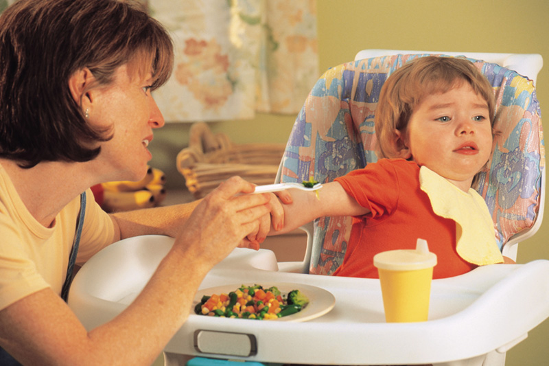 Mother having trouble feeding her daughter who is a picky eater