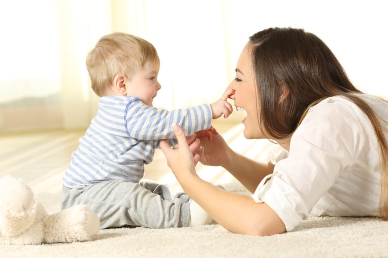 Happy baby touching his mother face