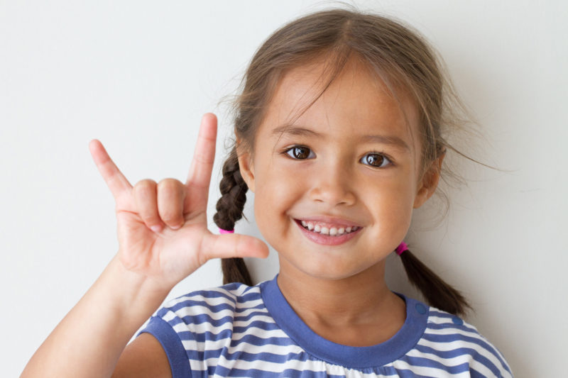 cute little girl showing I love you hand sign