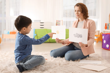 Female psychologist working with boy with autism