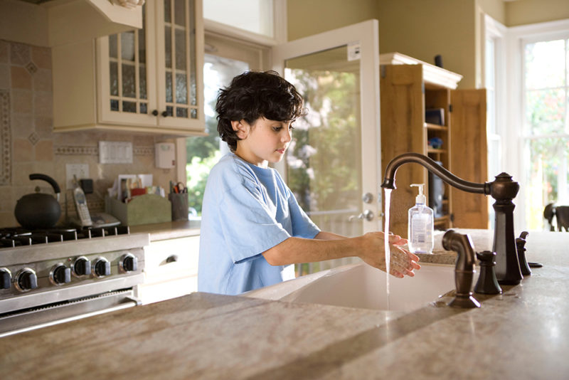 young boy washing his hands