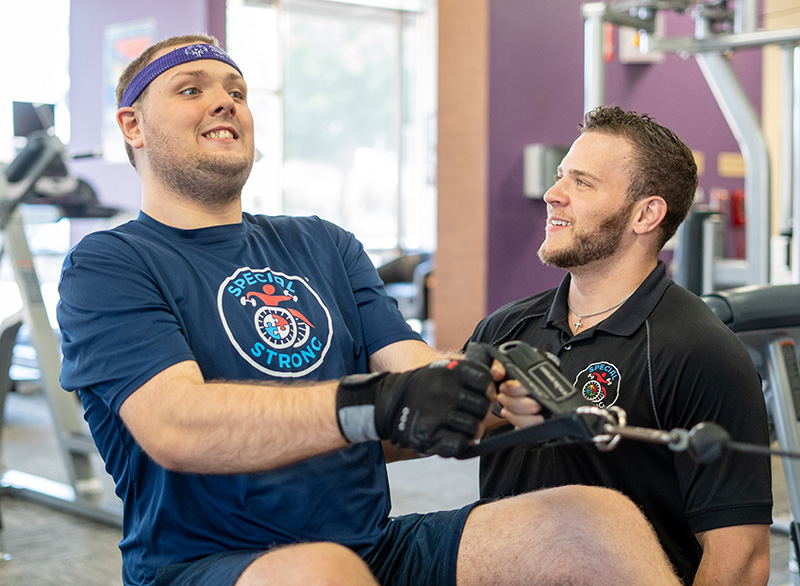 Daniel Stein, founder of Special Strong, performing a low row with scapula retraction to improve the posture of his special needs client, Robert.