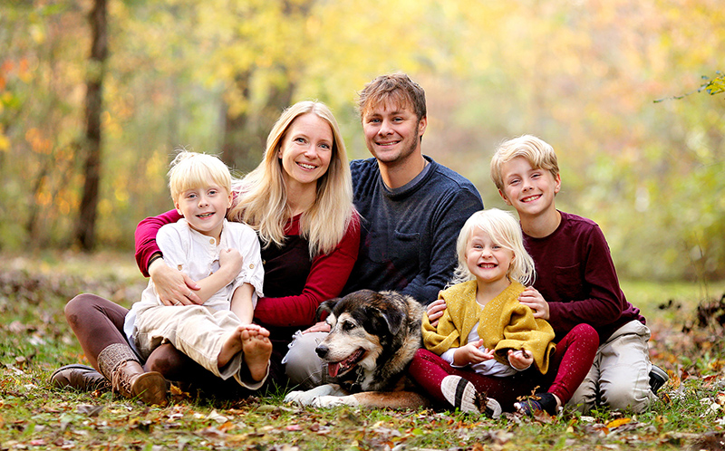 Portrait of Happy Young Family with three Cute, Smiling Children and their Pet Dog on Autumn Day
