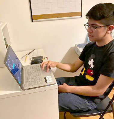 Oscar Roman has grown so comfortable on his laptop, that his father calls him "the teacher."