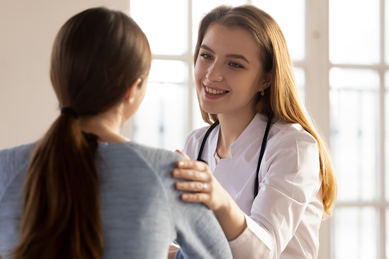 Compassionate, smiling nurse telling good health treatment results news