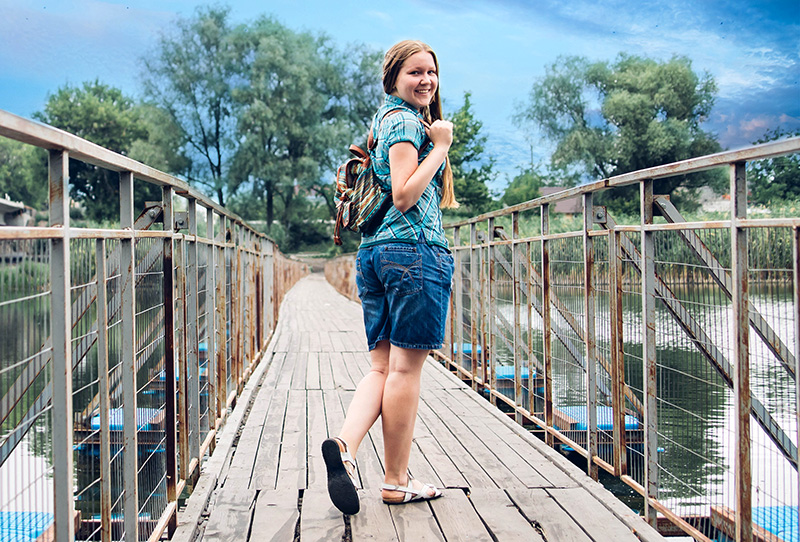 Adolescent girl walking across a bridge