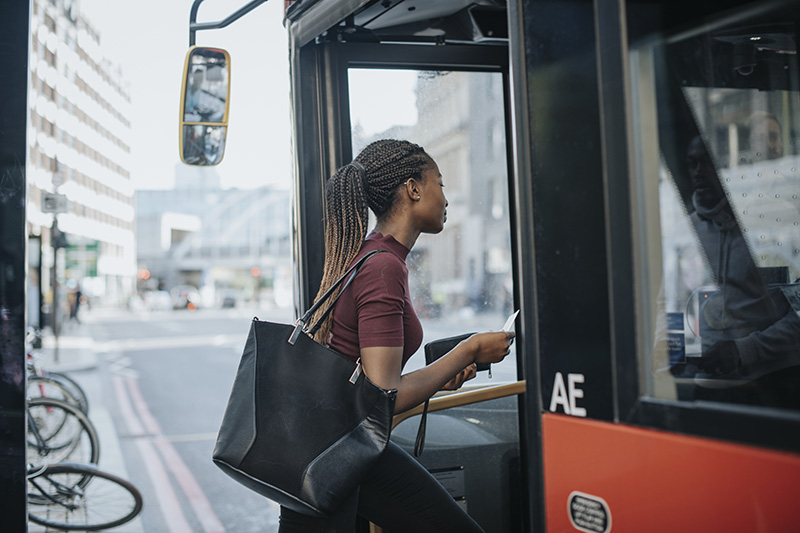 woman getting on the bus commuting to work