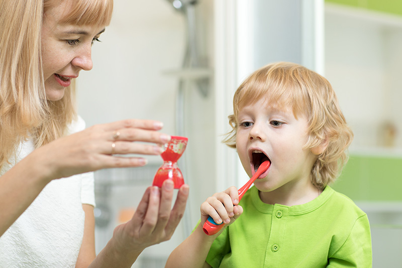 A toddler brushing his teeth in the bathroom