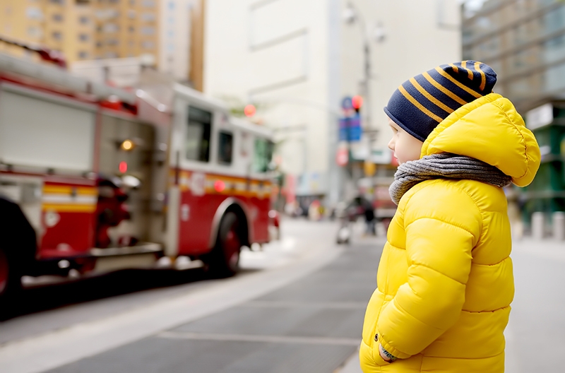 Little boy watches a fire engine