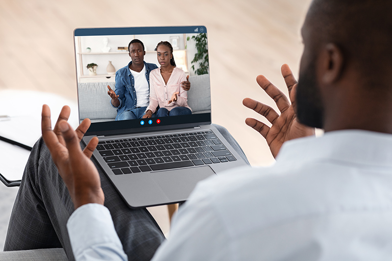 Family therapist consulting young black couple online for telehealth therapy session