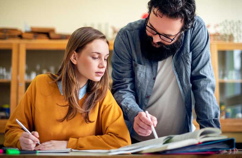 Teacher helping his student