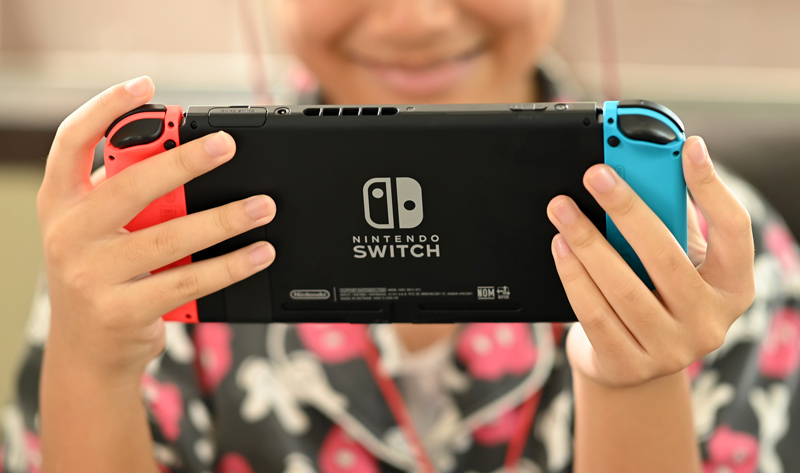 young adult playing with a Nintendo Switch