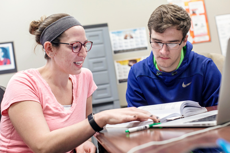 Graduate Assistant Maggie Miller assists student Mason White