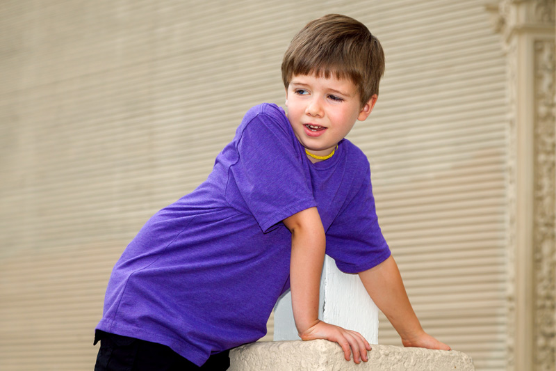 Double jointed young boy with hypermobility of the elbow leans forward with weight on his arm